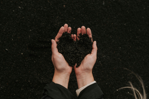 Hands cradling soil to represent the connection between mineral-rich earth and human well-being.