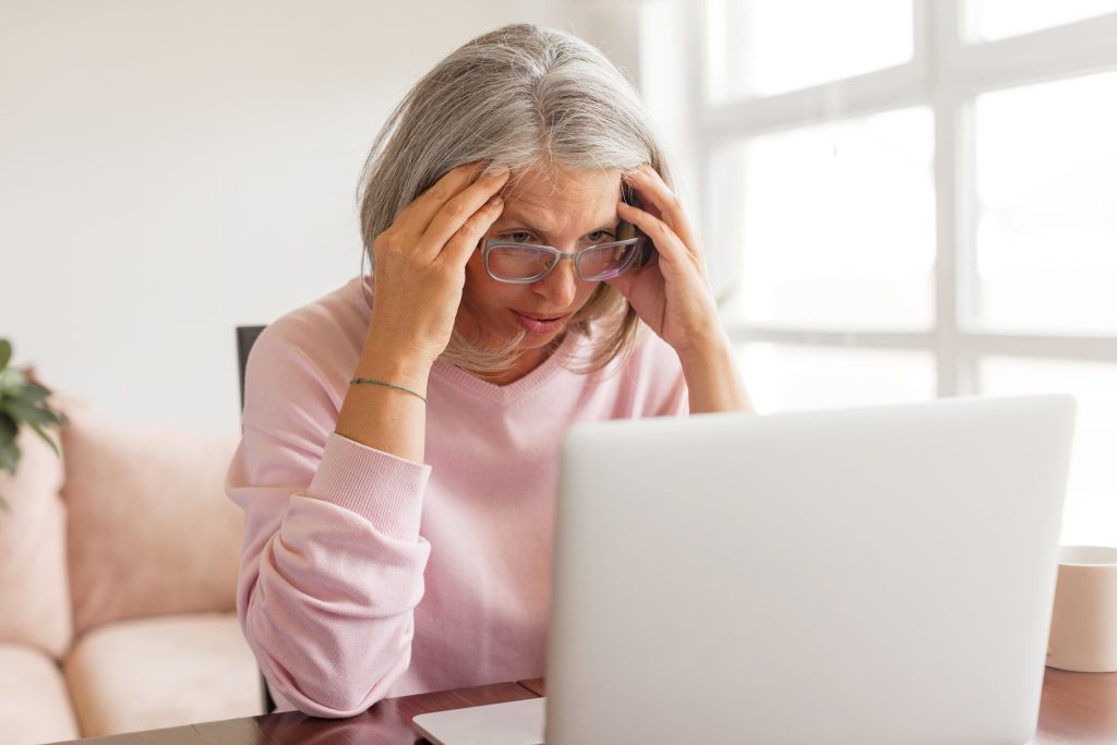 Older woman experiencing stress, symbolizing how aging and lifestyle factors can affect neuroplasticity and cognitive resilience.